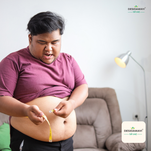 A smiling man holding a measuring tape around her waist, standing next to a traditional wooden table arranged with classical Ayurveda medicine for obesity, herbal powders, a brass mortar and pestle, and green Vrikshamla fruits.
